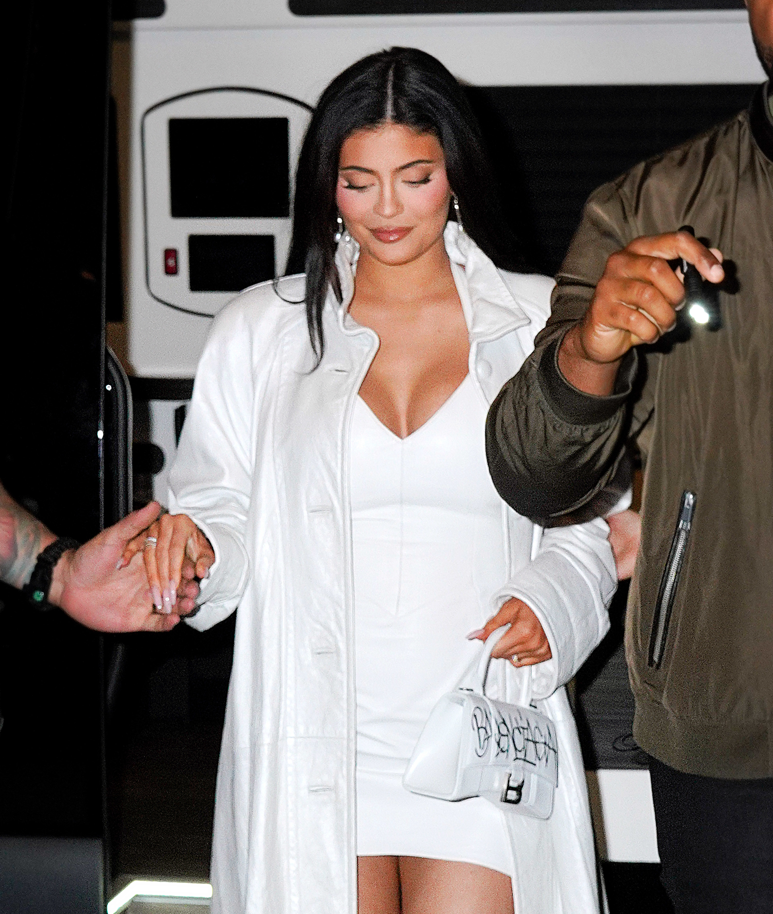 a pregnant Kylie holds someone&#x27;s hand to get out of a vehicle