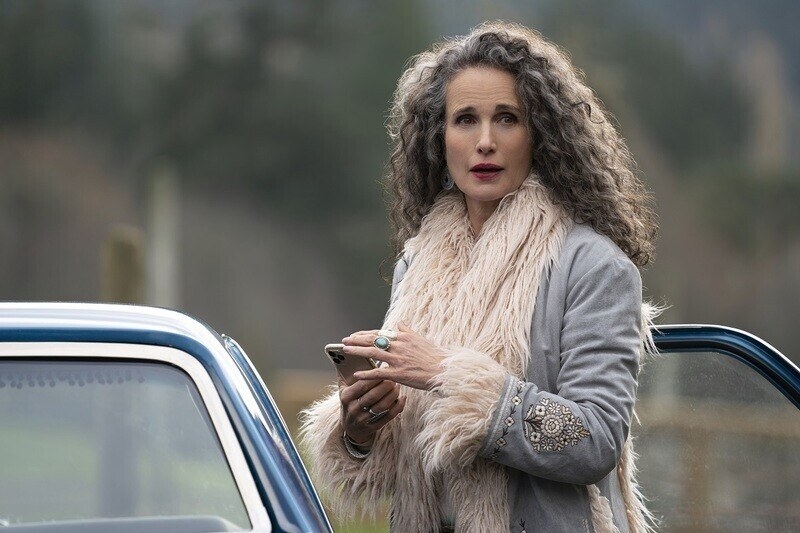 A woman is standing beside a car.