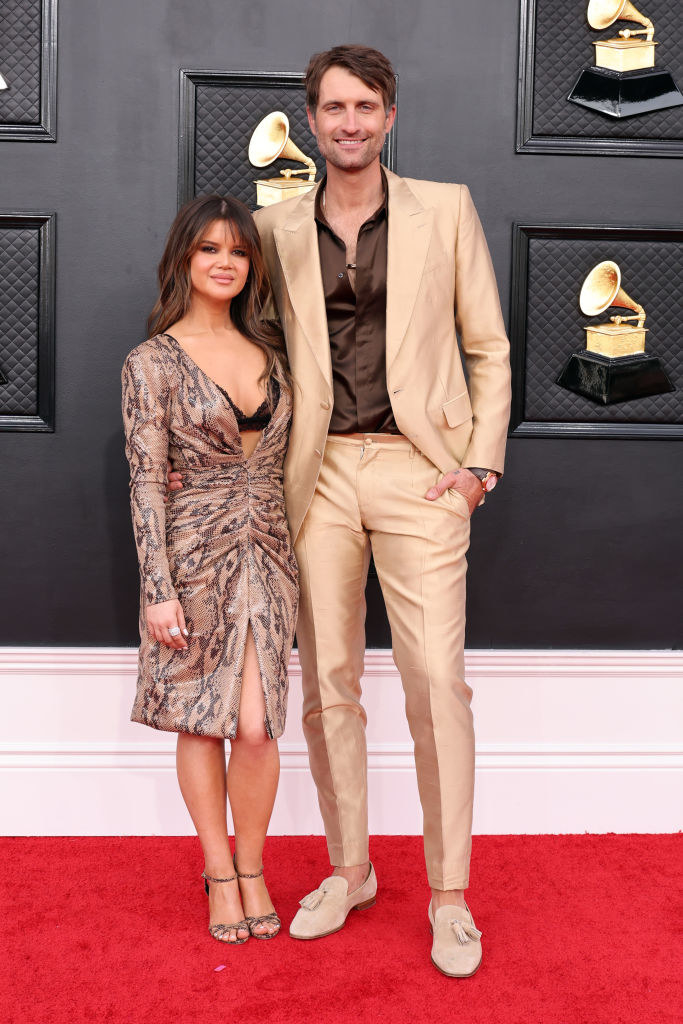 Maren in a knee-length, long-sleeved dress and Ryan in a shiny, light-colored suit