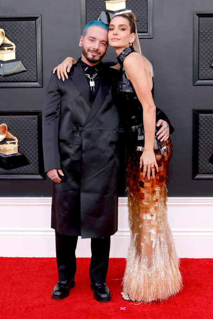 J Balvin in a shiny, long suit jacket and Valentina in a straight, shiny, halter-top gown