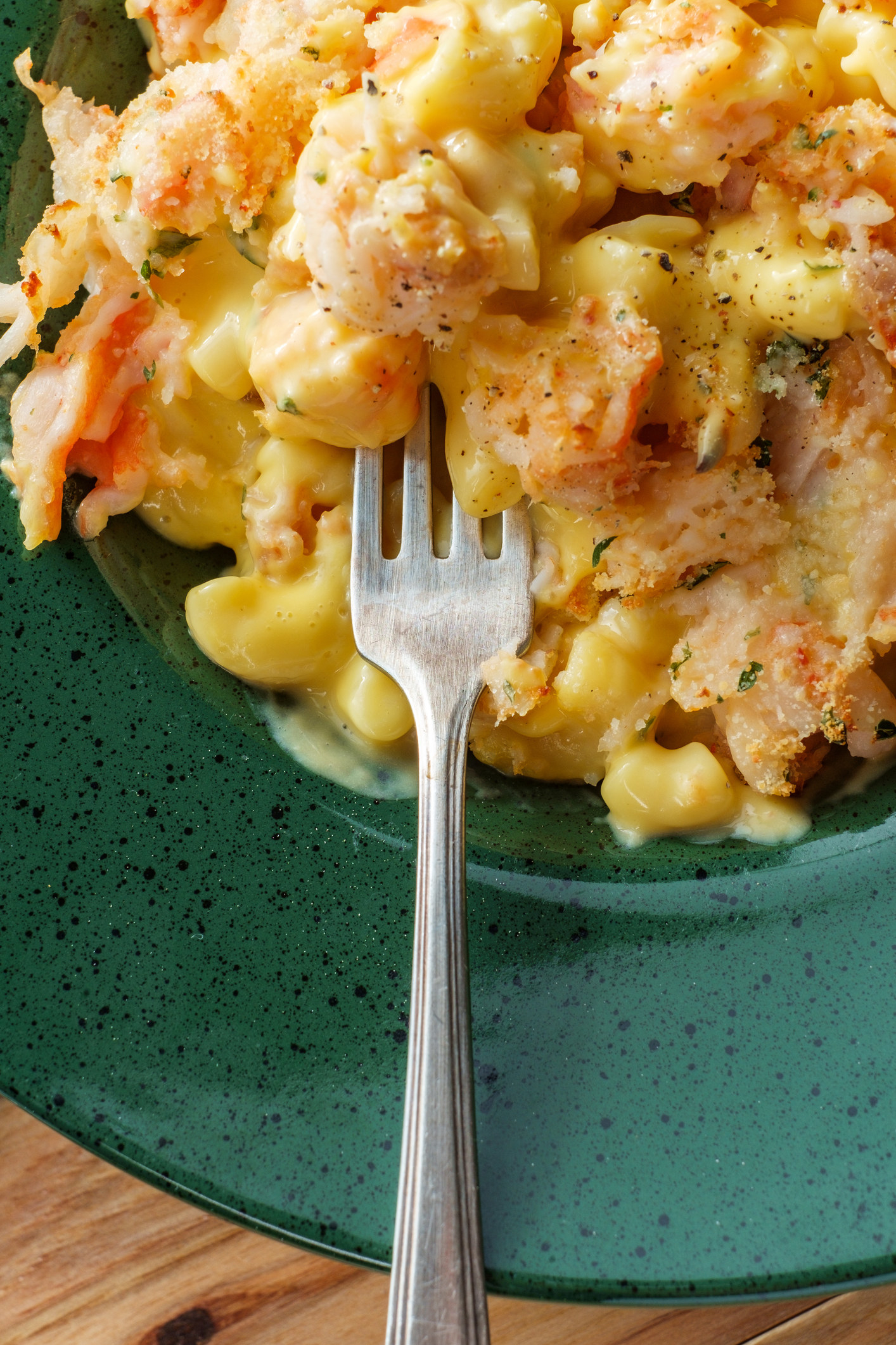 A fork digging into a bowl of lobster mac &#x27;n&#x27; cheese.