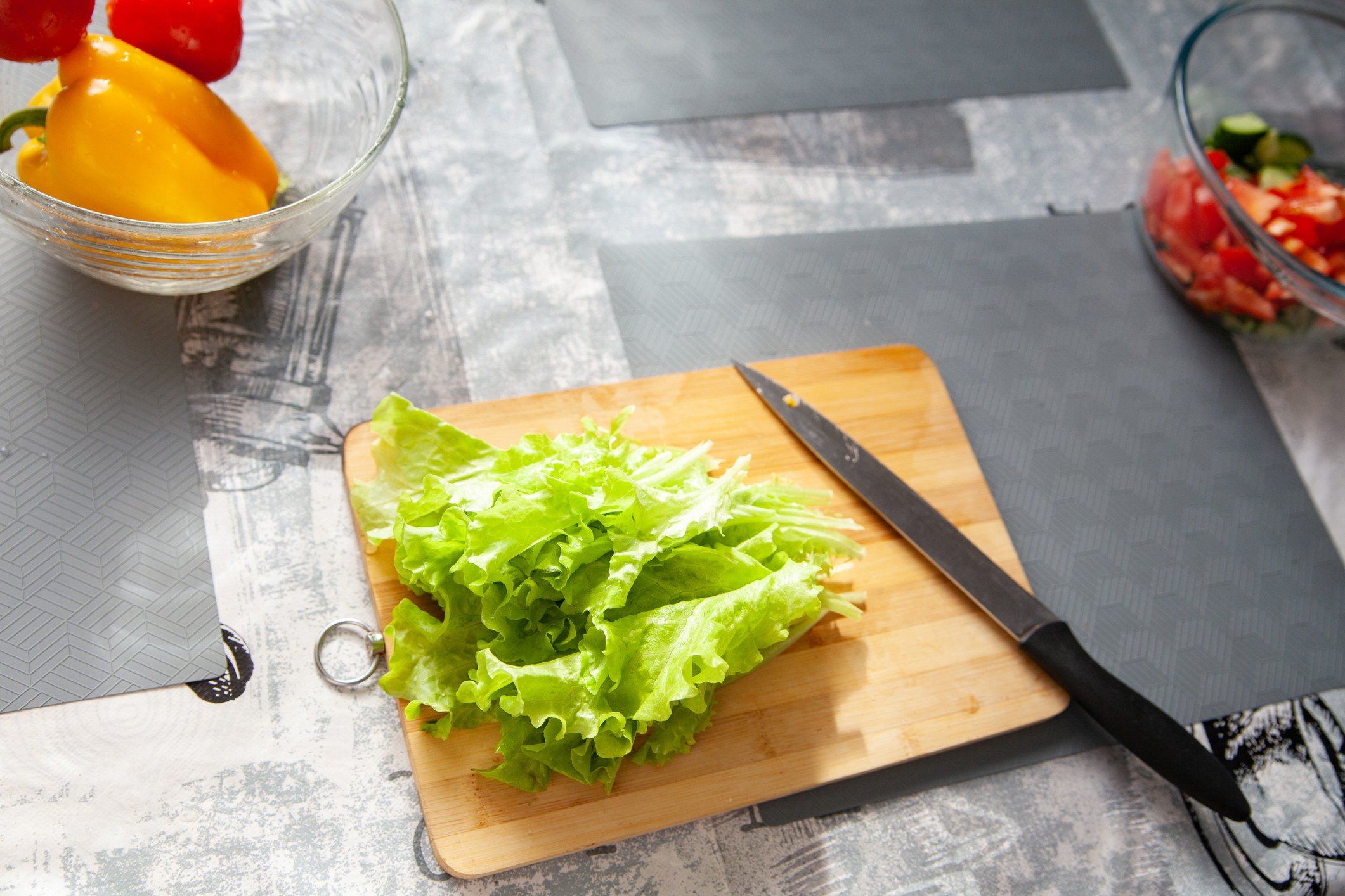 High angle of lettuce leaves on chopping board with knife.