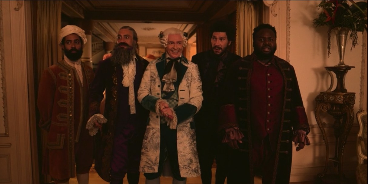 Blackbeard, Stede, Frenchie, and Oluwande, all in their finest clothes, take in a scene before them on a ship where a party is being hosted. They are joined by a member of that ships&#x27; crew.