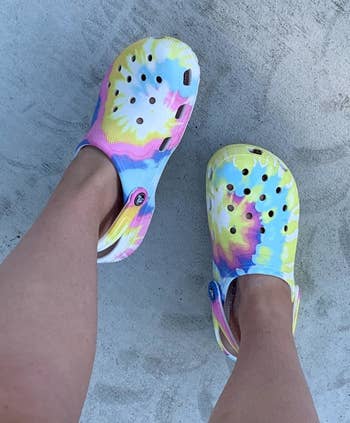 reviewer in pink, yellow, and blue tie-dye Crocs
