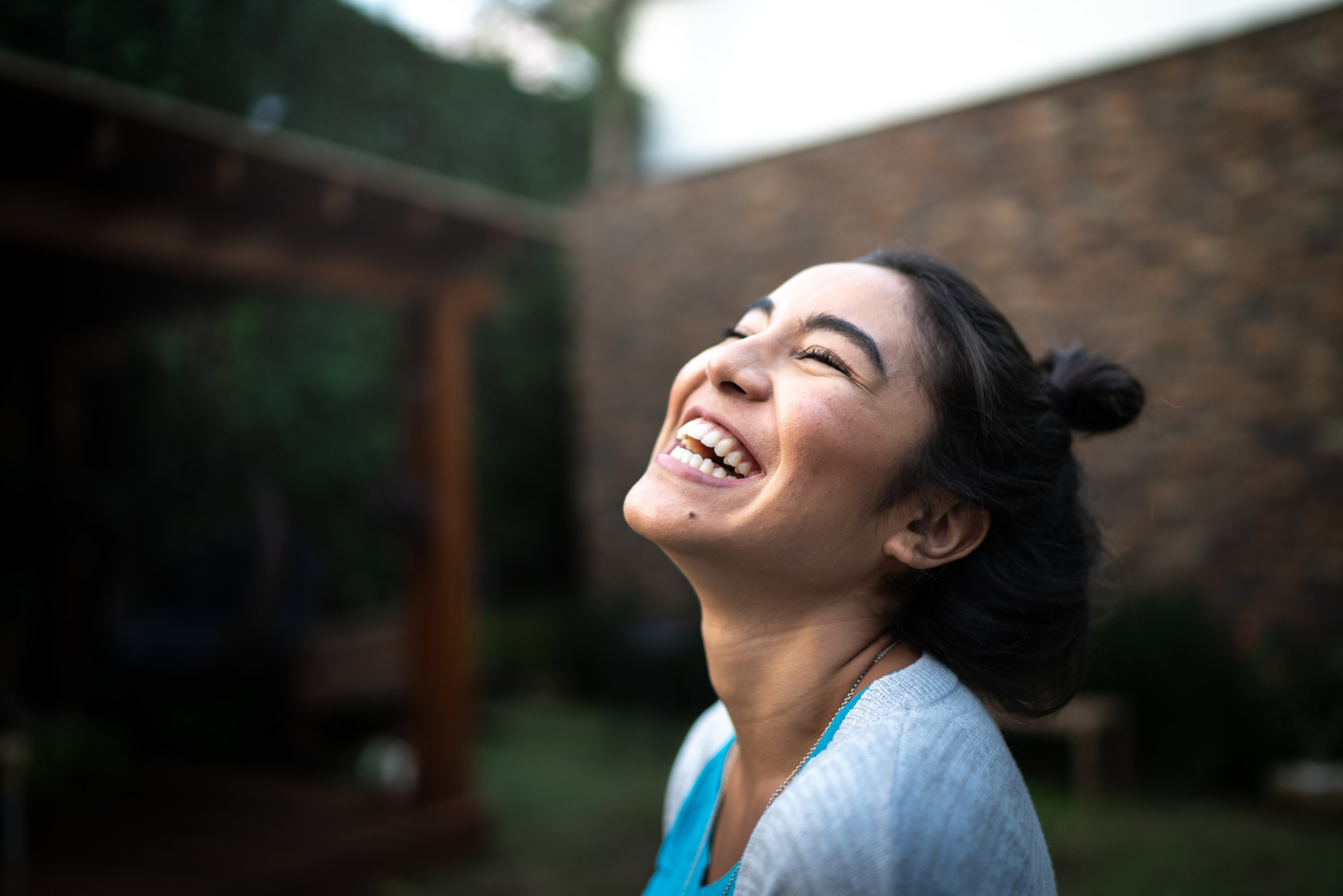A woman laughing outdoors