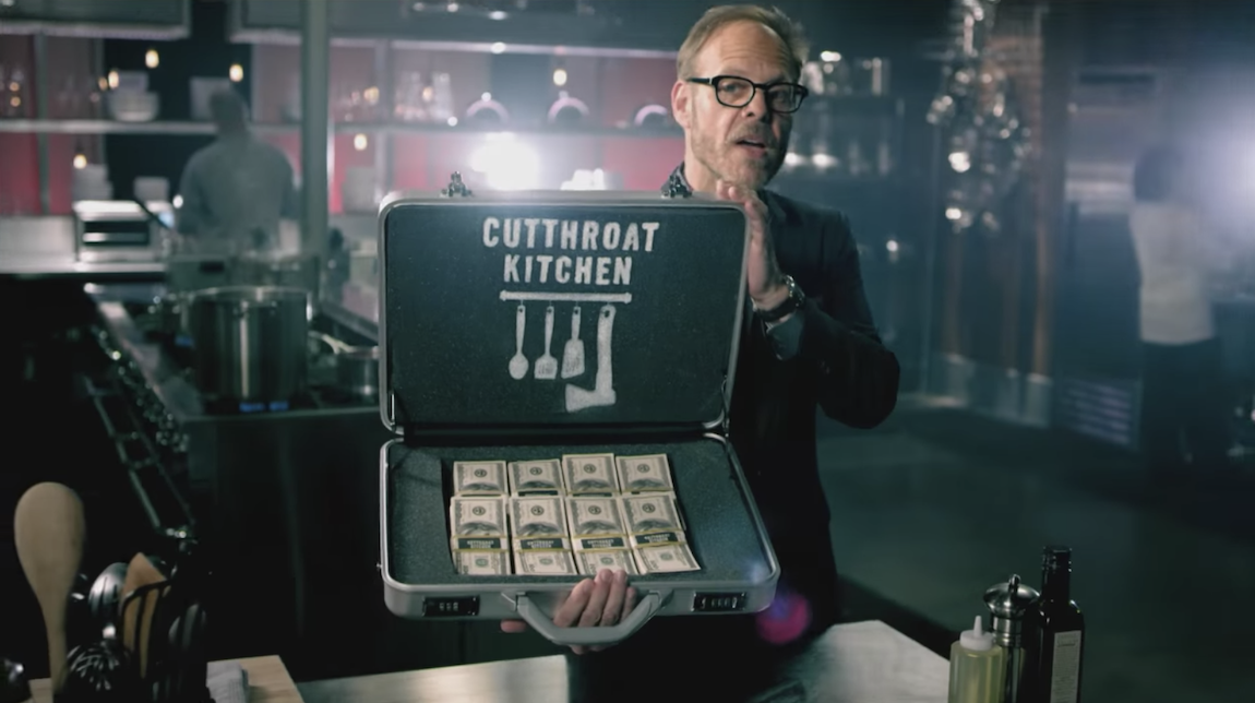 Alton Brown holding a suitcase of money on &quot;Cutthroat Kitchen.&quot;