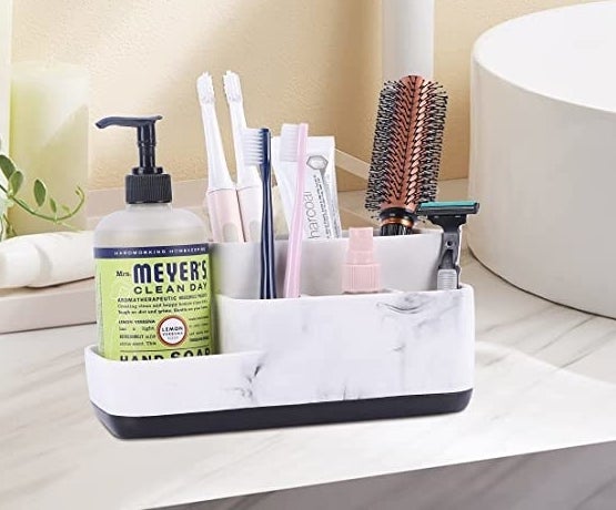 The caddy on a bathroom counter holding personal care products