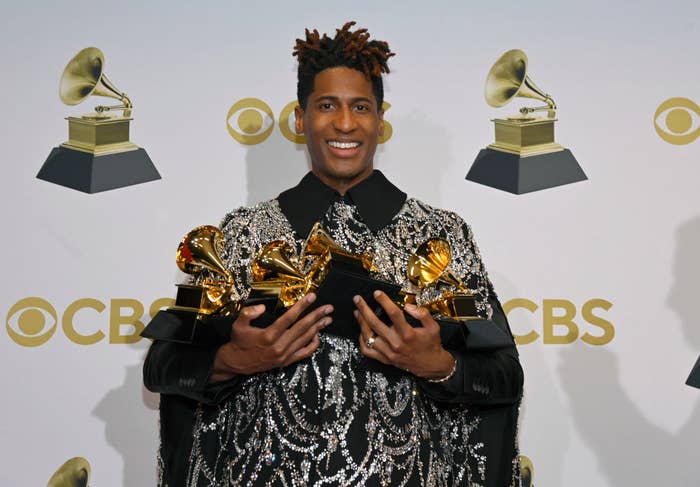 Jon holding his awards backstage and smiling
