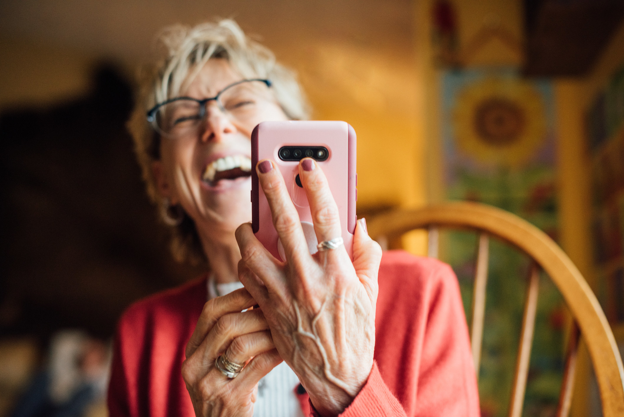 A woman laughing at her cellphone.