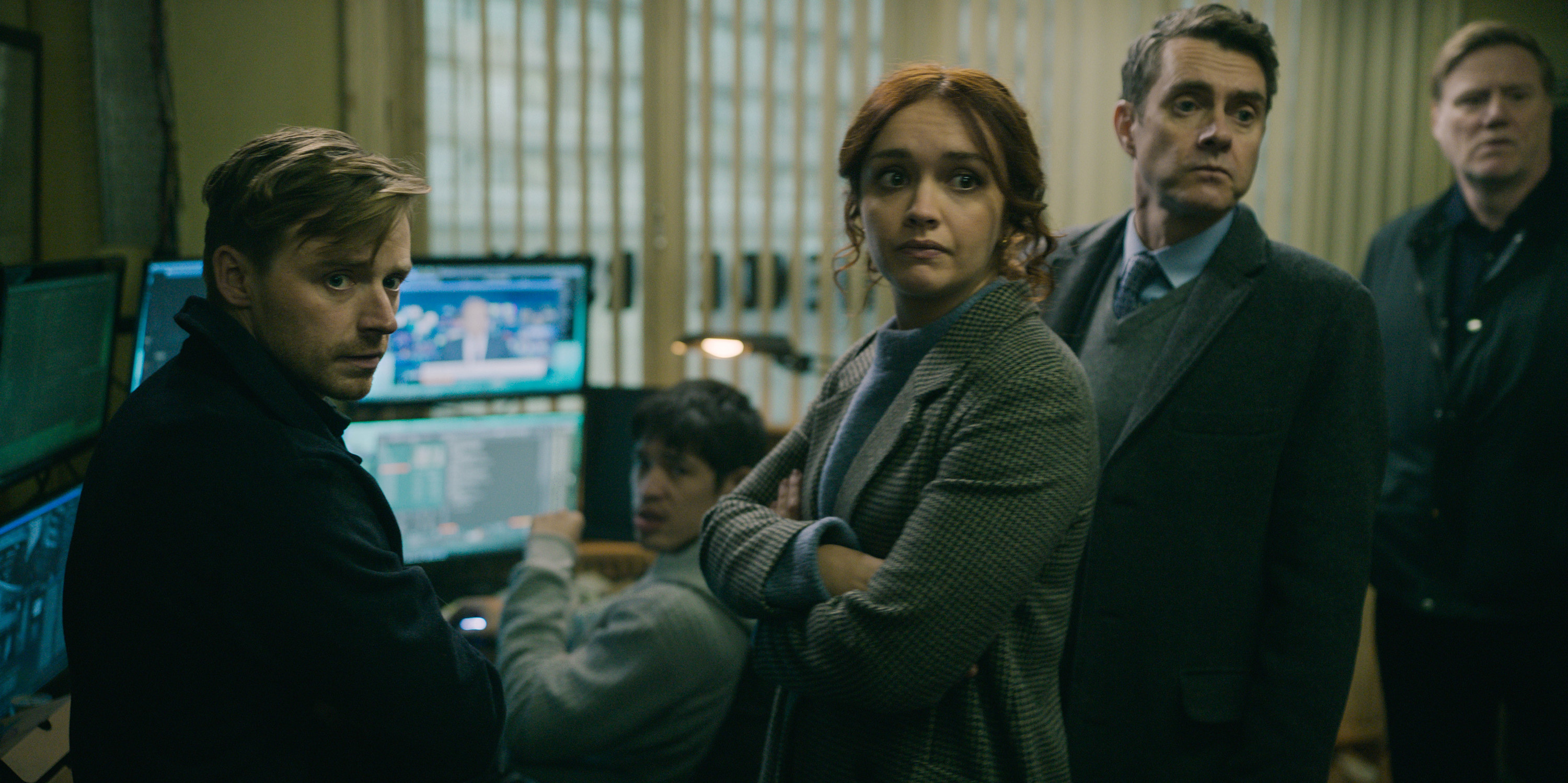 Jack Lowden, Olivia Cooke, and Paul Higgins stand around a computer