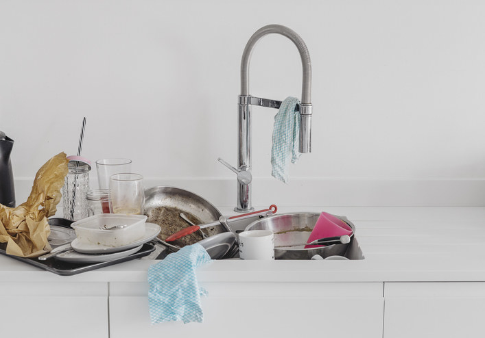 A kitchen sink overflowing with dirty dishes