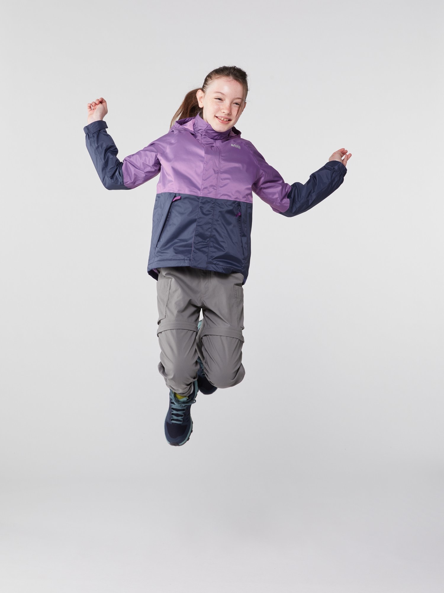 child model jumping in the purple raincoat
