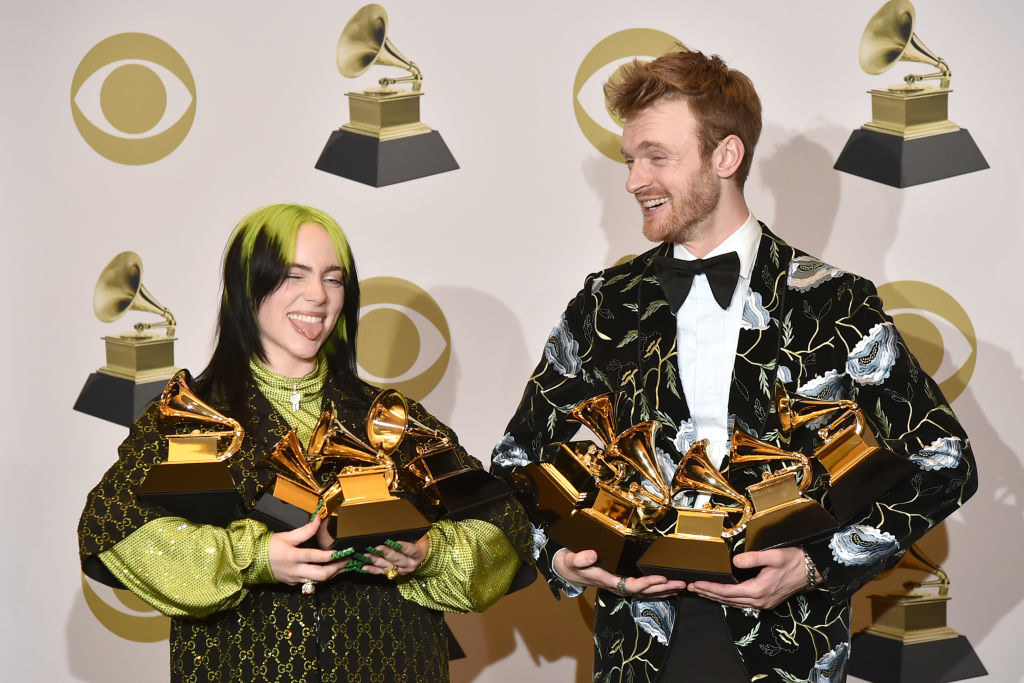 Billie and Finneas stand next to each other while they hold their awards