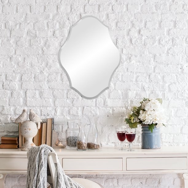 the frameless mirror hanging on a wall