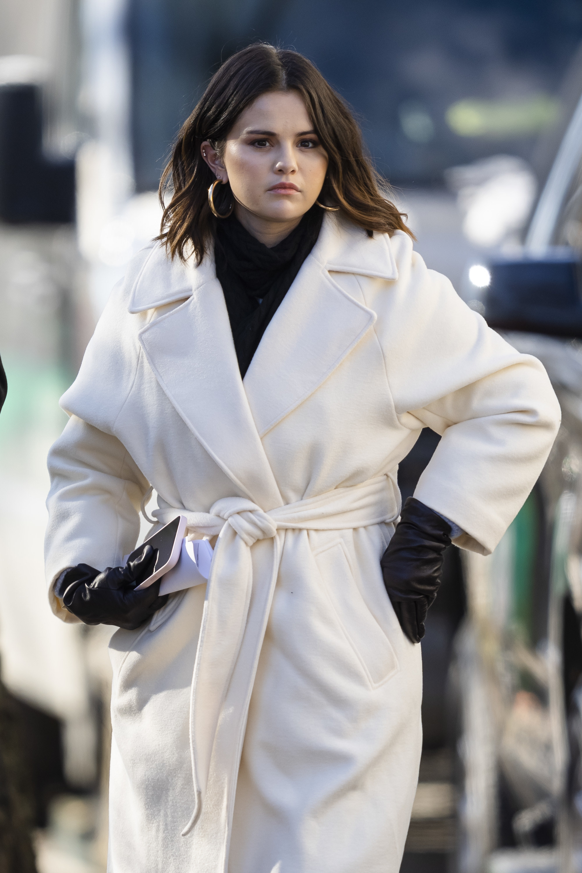 Selena walking outside as she wears a big coat and gloves