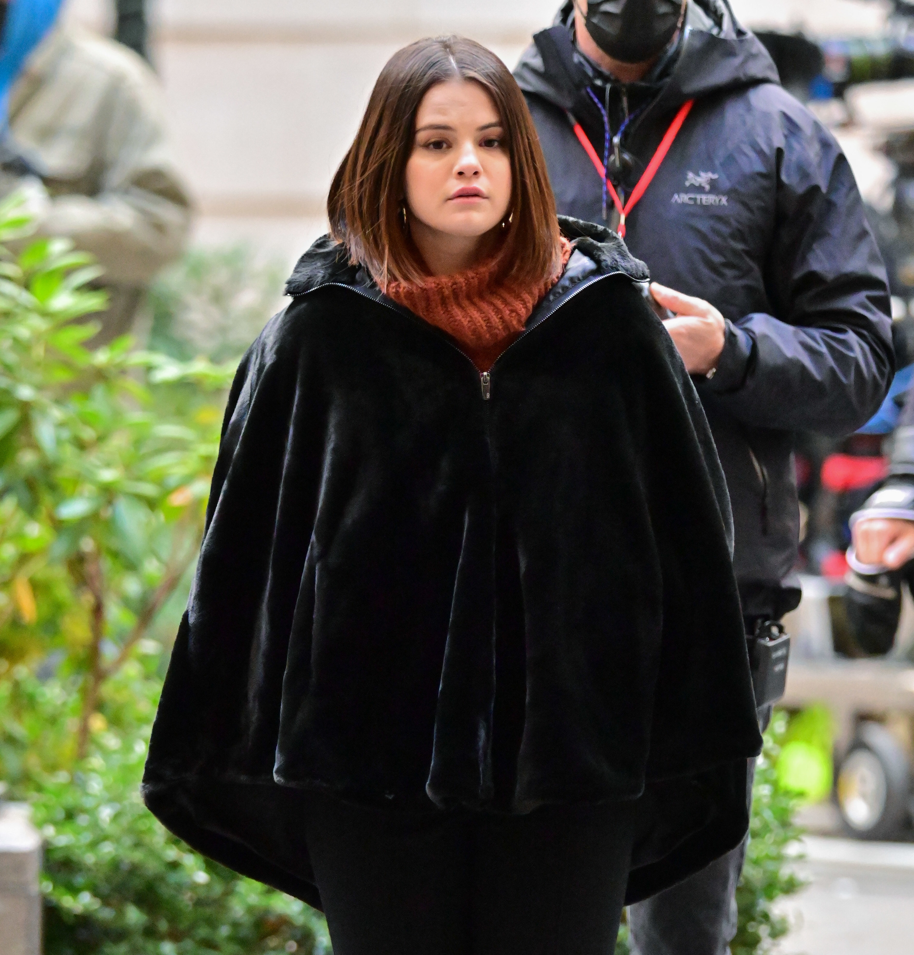 Selena looks ahead while wearing a coat