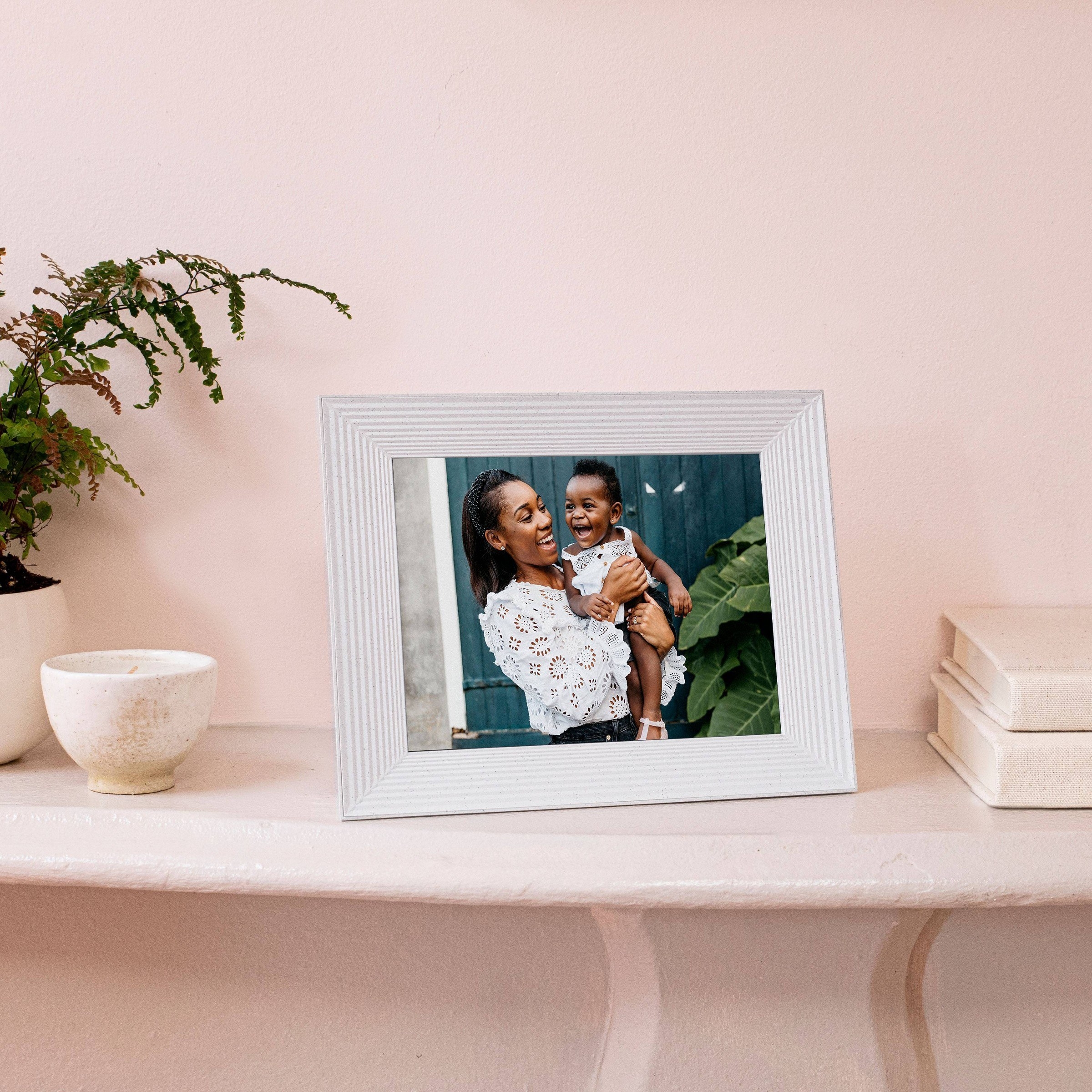 the frame in white showing a photo of a mother and toddler
