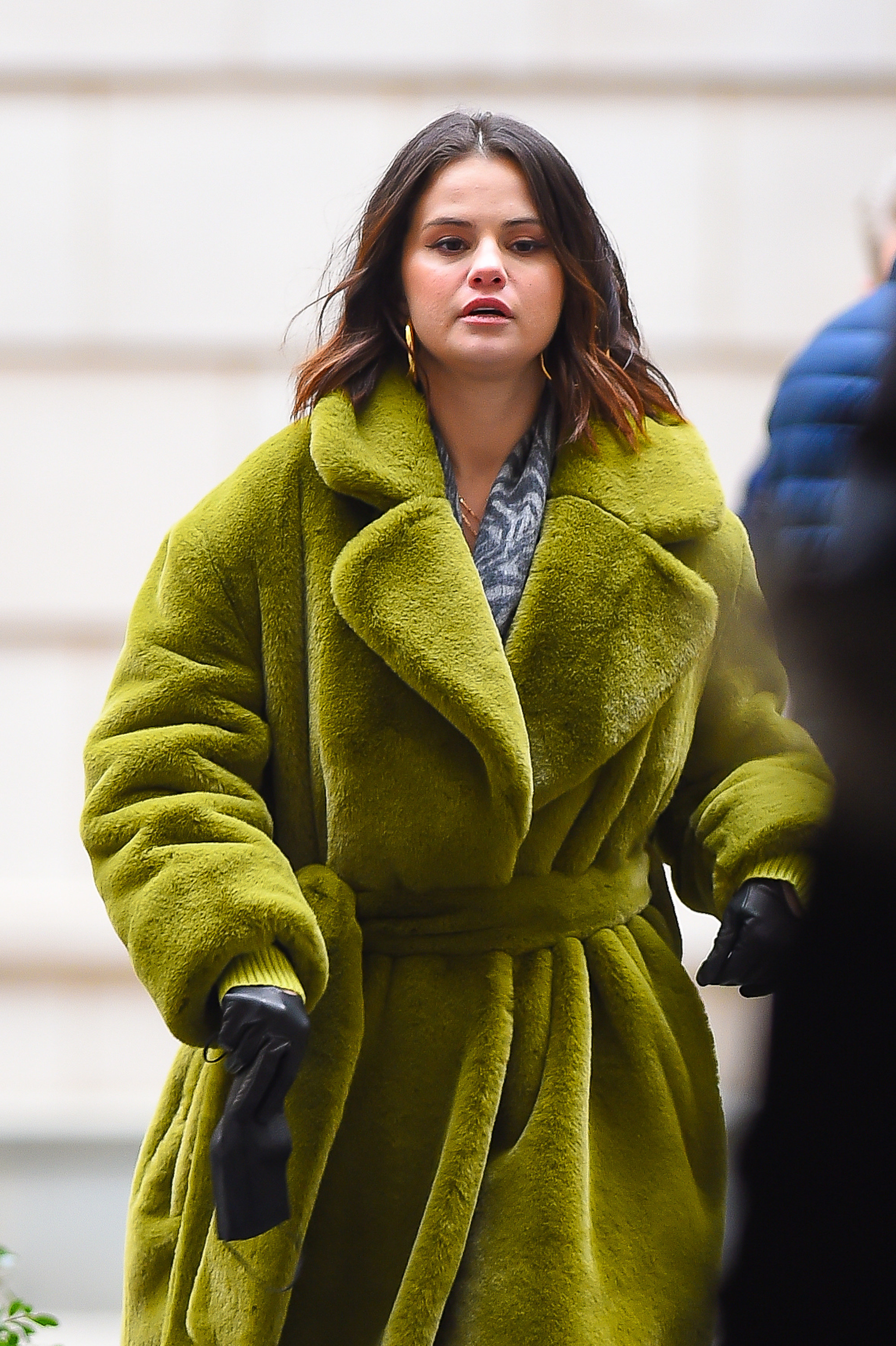 Selena walks in a fluffy coat