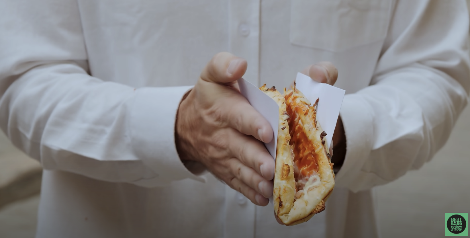 A person folds a Cuban pizza