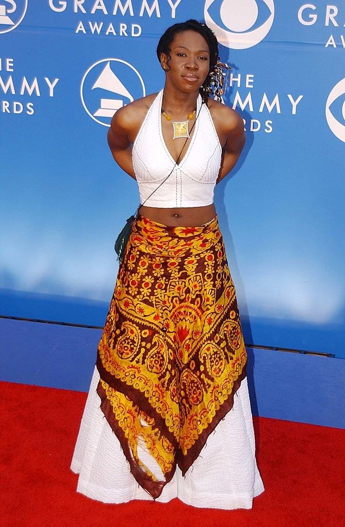 Wearing a light-colored halter top and long, A-line skirt with a handkerchief-type shawl wrapped around it