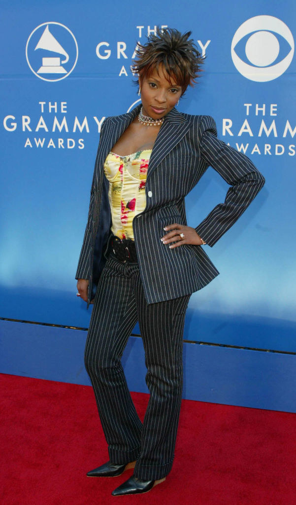 Wearing a striped pantsuit with a corset top and hand on hip