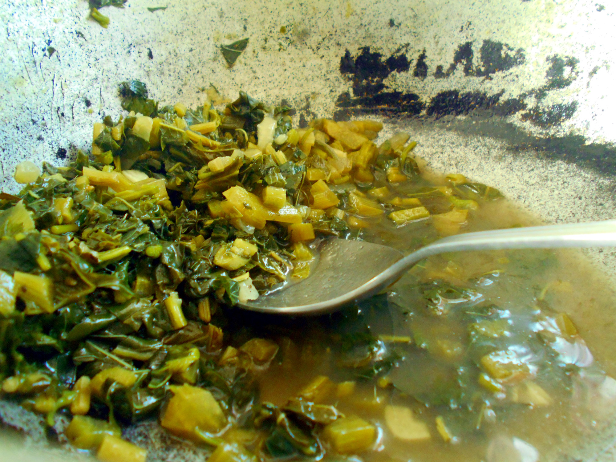 Callaloo soup in a pot with a spoon