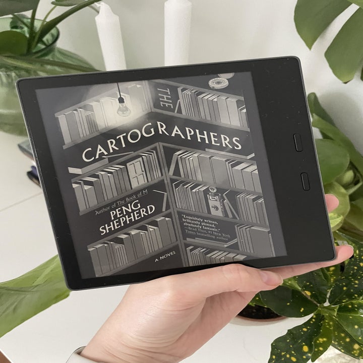 Alice holding the Kindle in front of plants