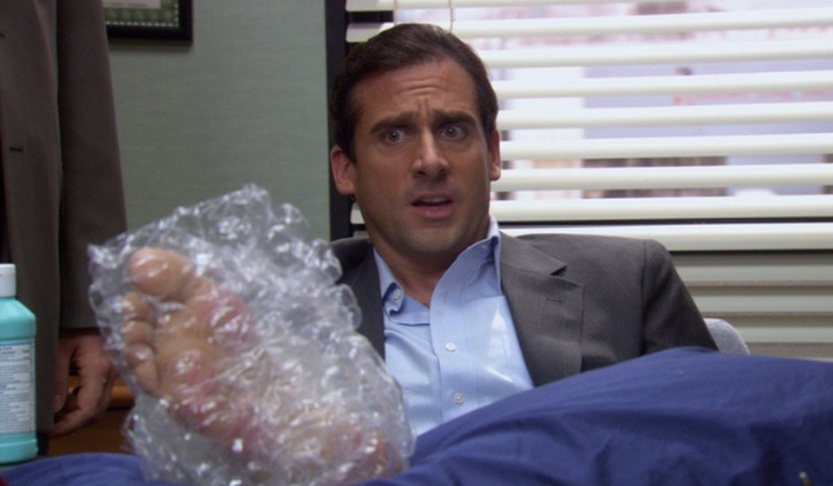 Steve Carell as Michael Scott with his foot wrapped in bubble wrap