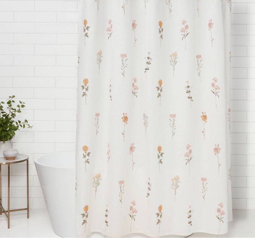 the white shower curtain with flowers on it