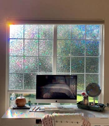 reviewer's work desk with the window film applied to the window above it and rainbows cast across the desk