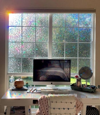reviewer's work desk with the window film applied to the window above it and rainbows cast across the desk