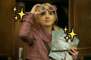 Luna Lovegood wears a wool blazer while holding her wand, several magazines, and is wearing colorful glasses