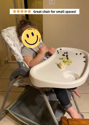 Reviewer's child eating in the high chair with the words 