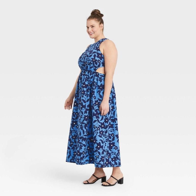 Model wearing blue floral dress with black shoes