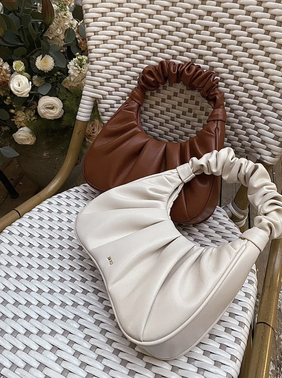 a white and brown purse in a chair