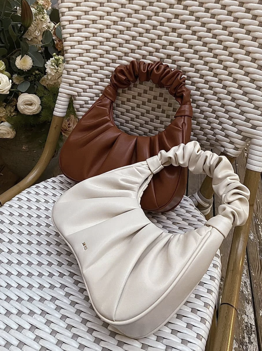 a white and brown purse in a chair