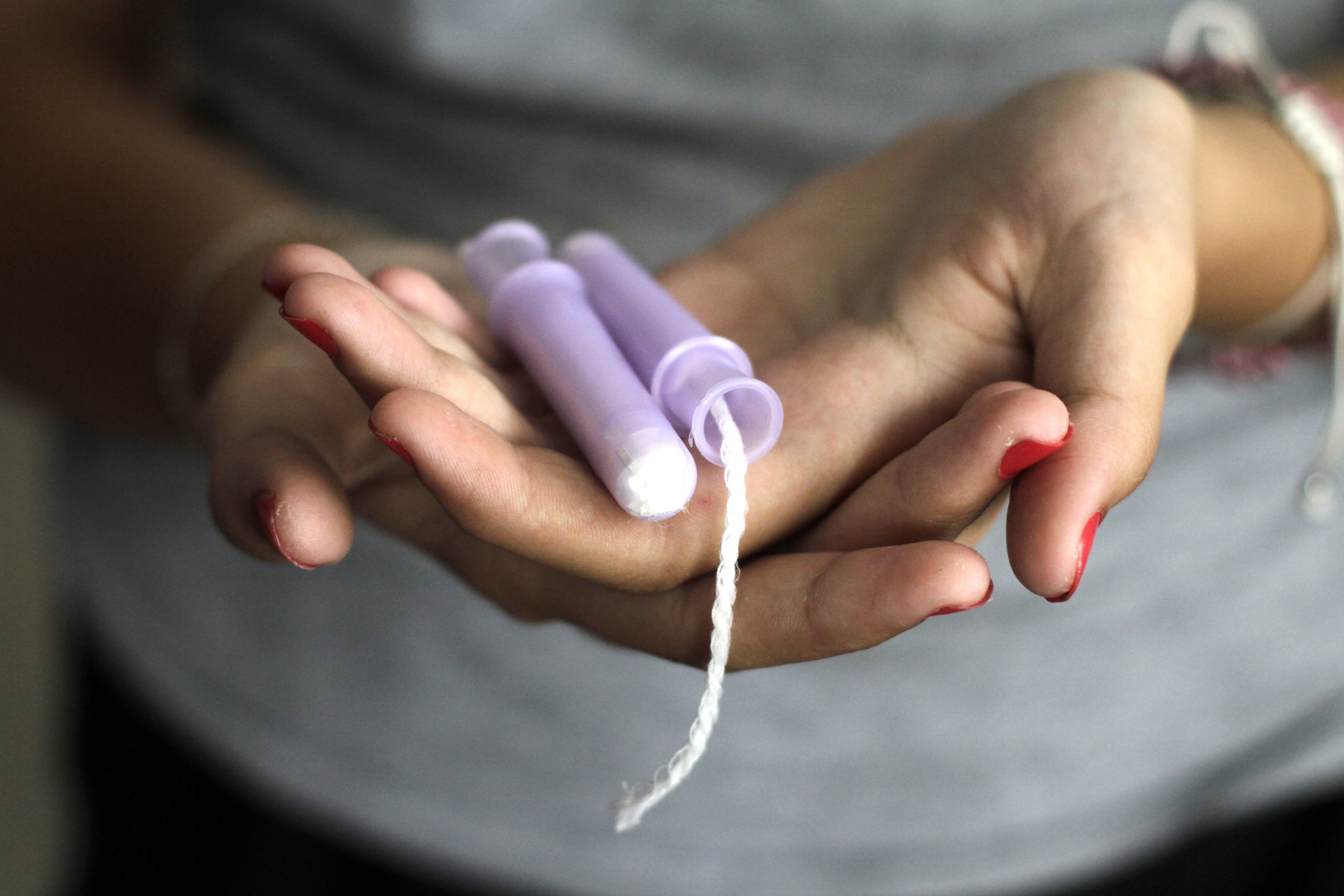 A woman holding a tampon.