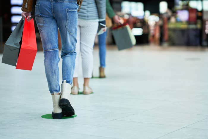 People's legs standing in line at a mall