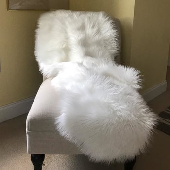 a chair with a white sheepskin rug draped across it