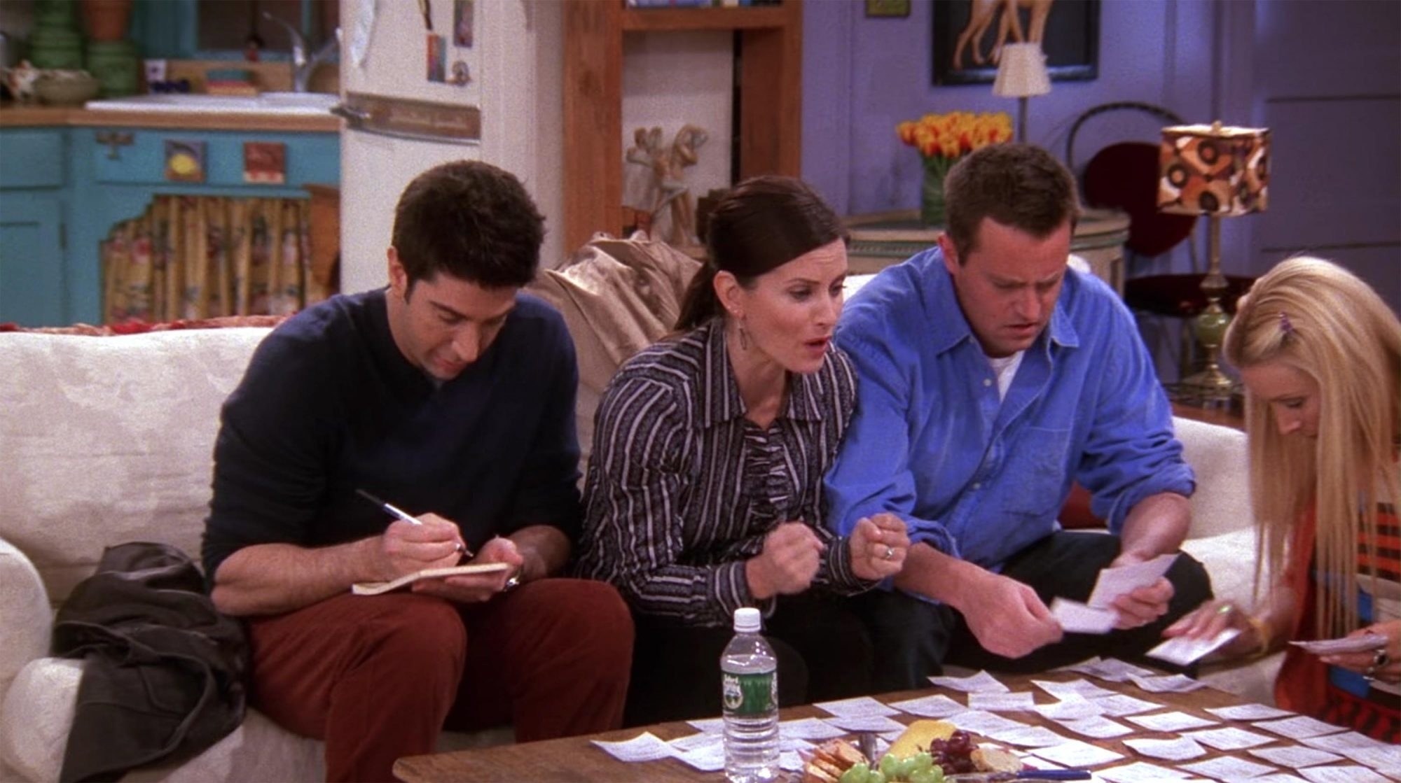 Ross writes on a notepad, Monica cheers, and Chandler and Phoebe lay out several lottery tickets on a coffee table