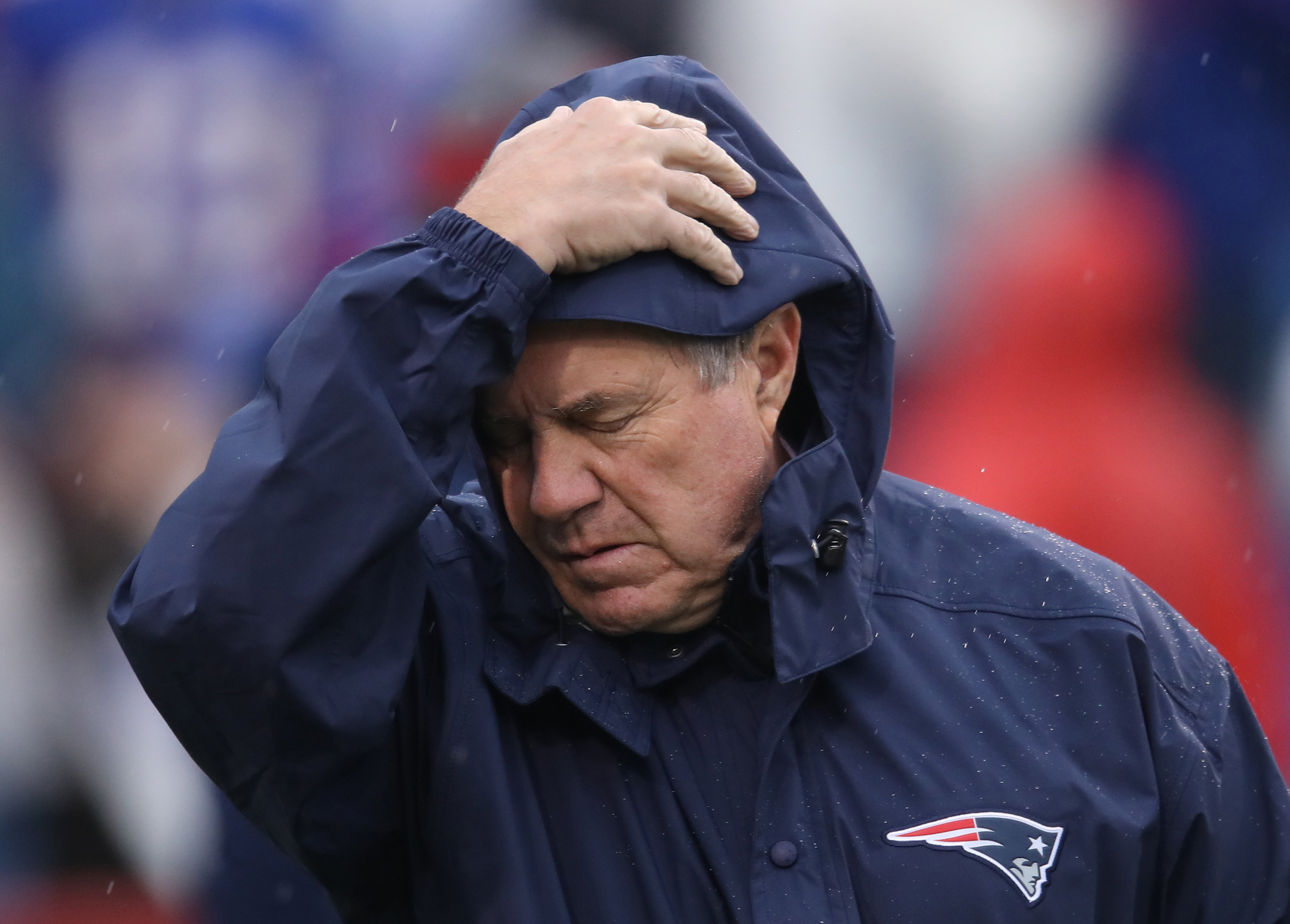 Bill Belichick wears a blue Patriots raincoat