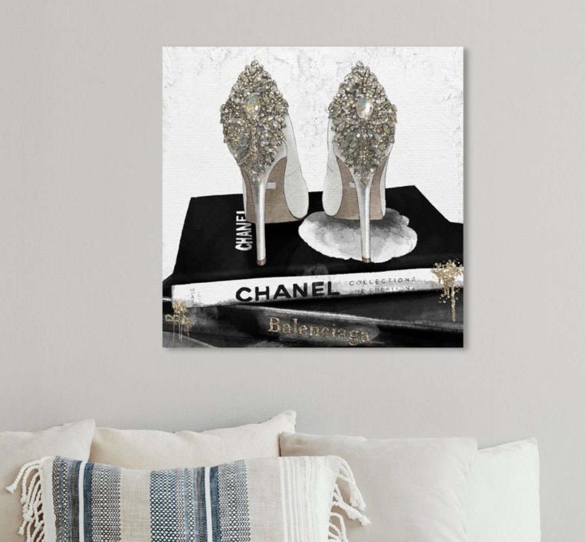Canvas art with heels on top of Chanel and Balenciaga coffee books.