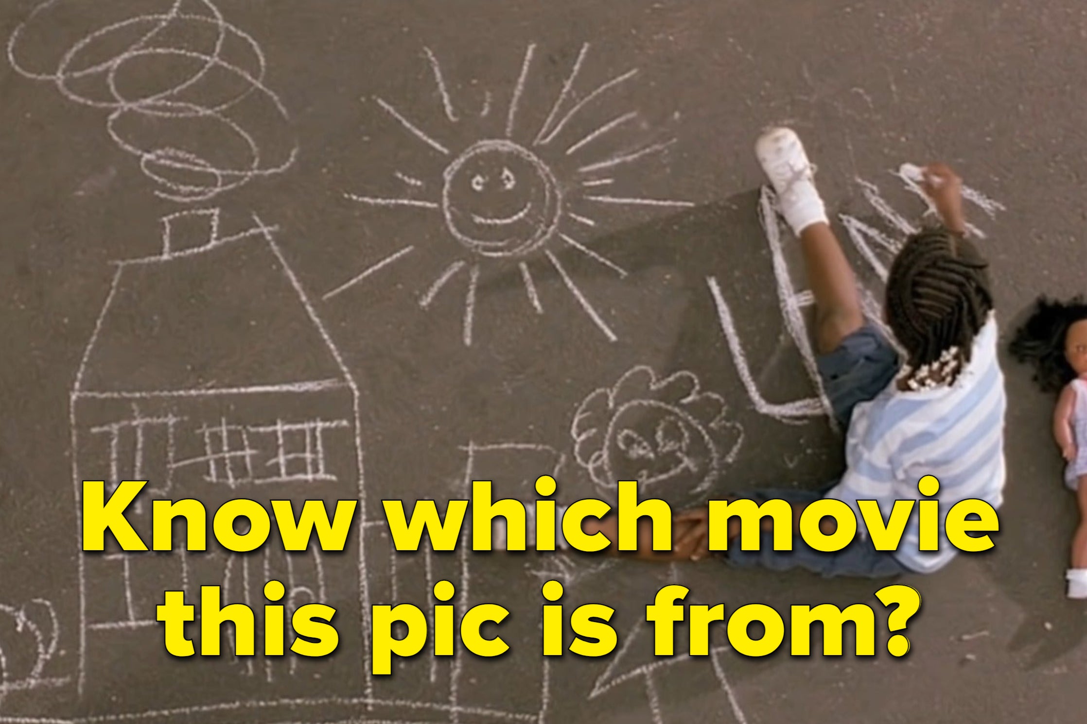 A child draws with chalk on the asphalt