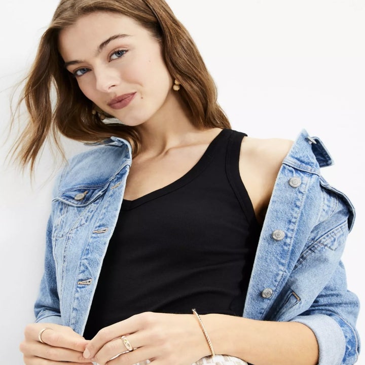 A different model wearing the blank tank under a jean jacket