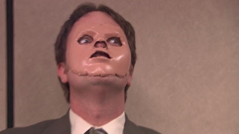 Rainn Wilson as Dwight Schrute wearing the cut off face of a CPR dummy