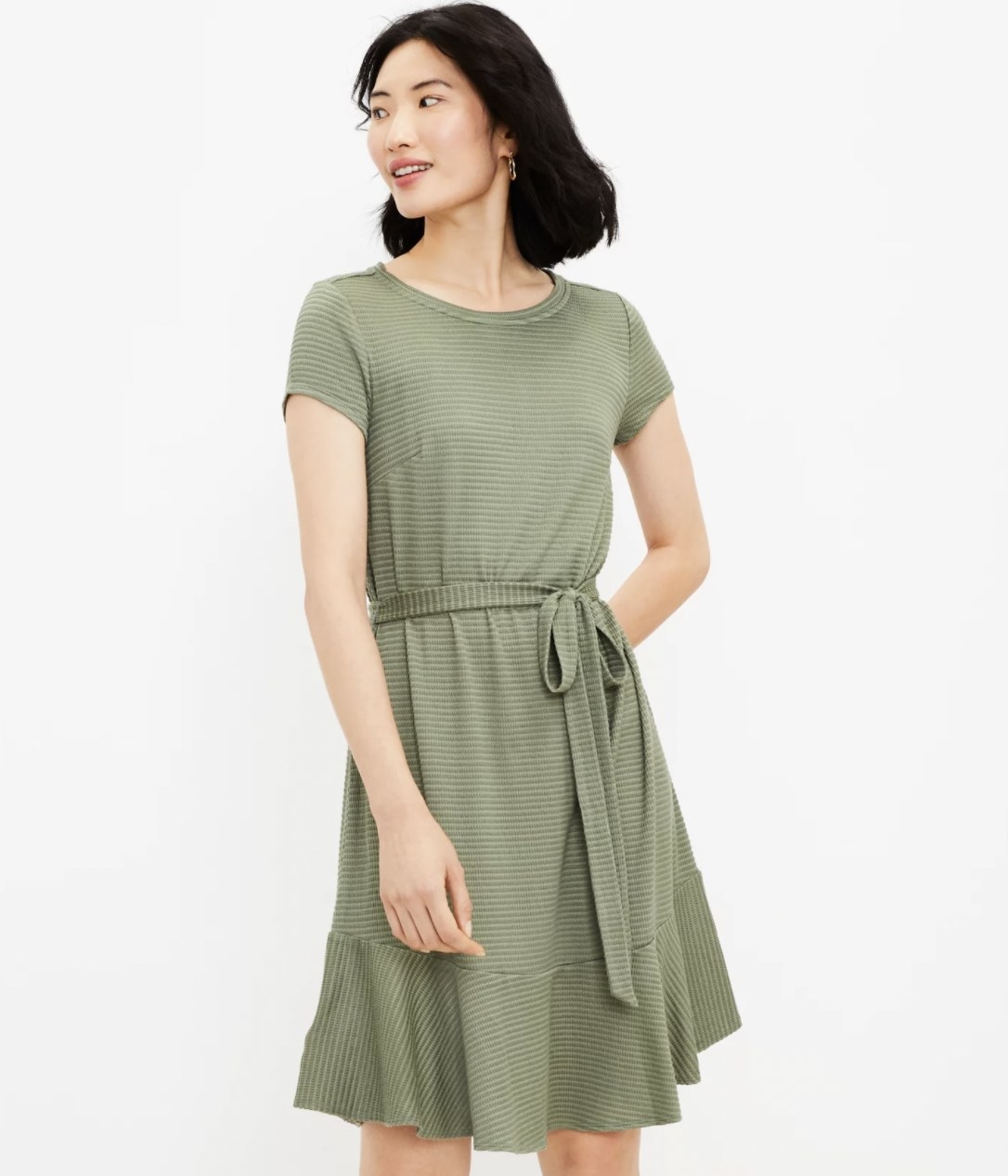 Model wearing the green short sleeve flowy dress with waist tied in a bow
