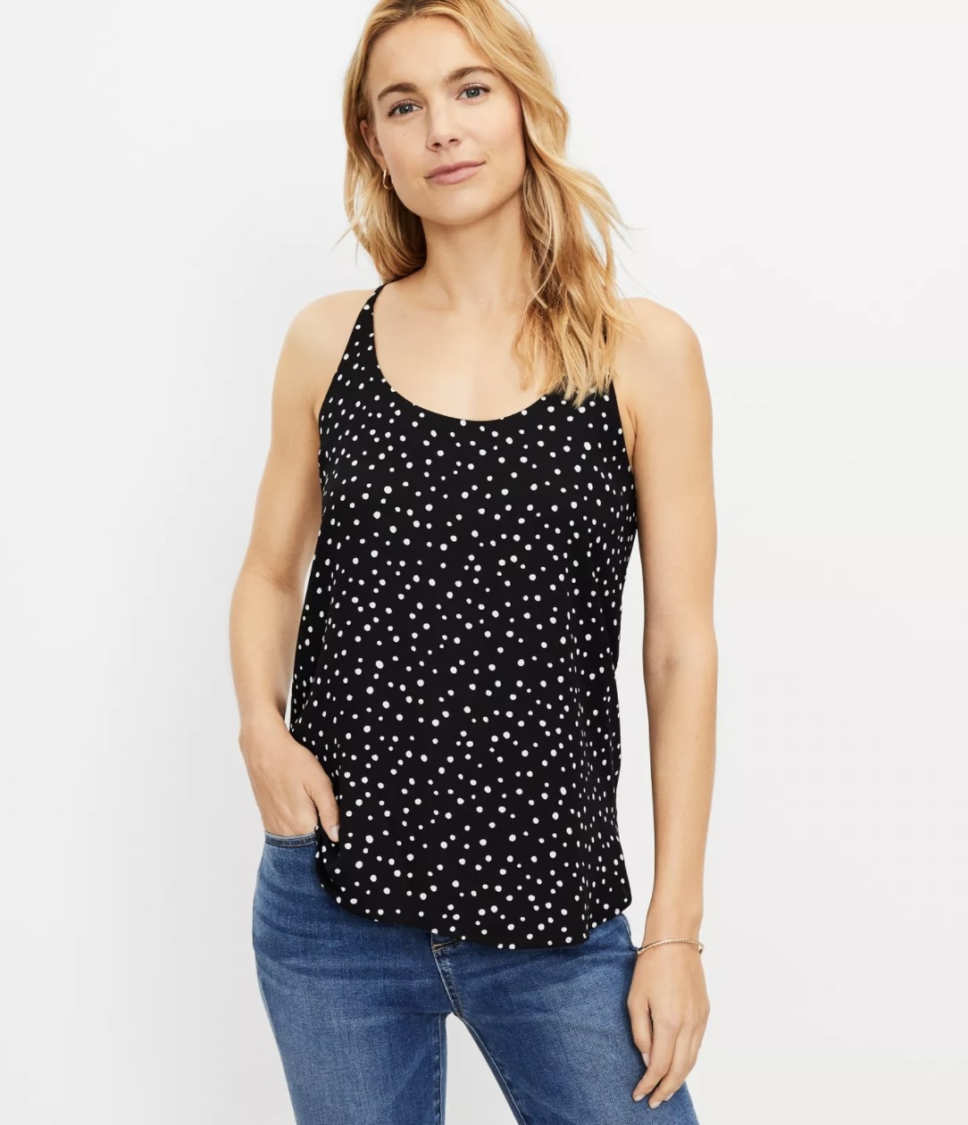 Model posing in the black with white dots scoop neck spaghetti strap cami