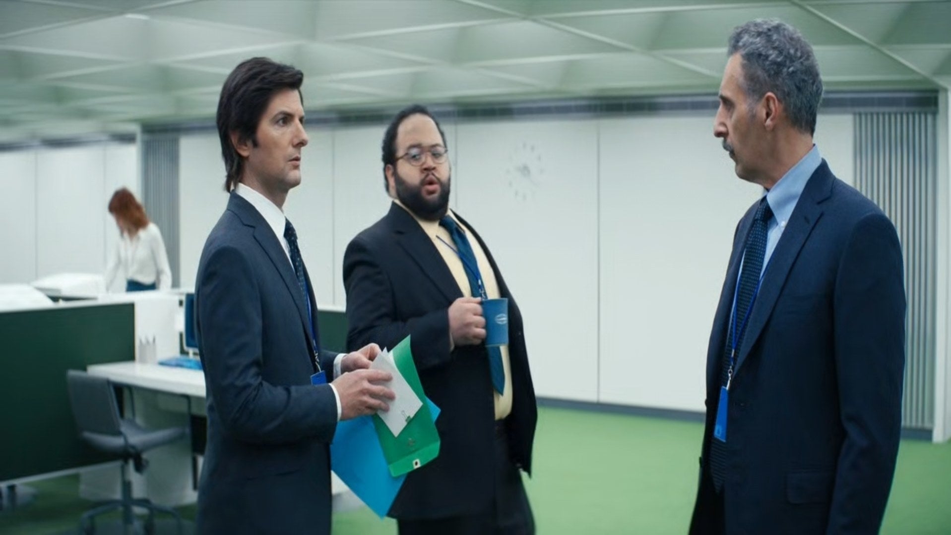 Adam Scott, John Turturro, and Zach Cherry discuss something while Britt Lower stands far in the background