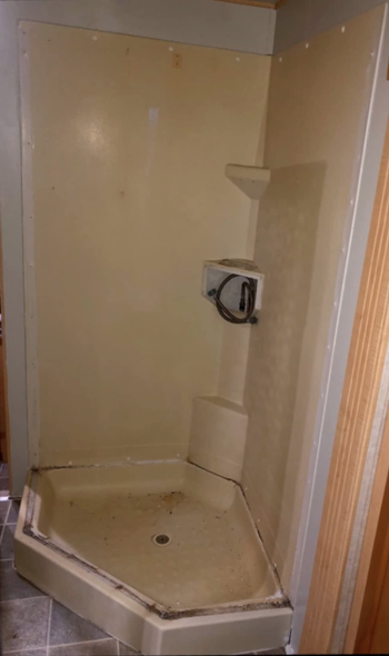 yellowed dingey and moldy looking shower surround and floor