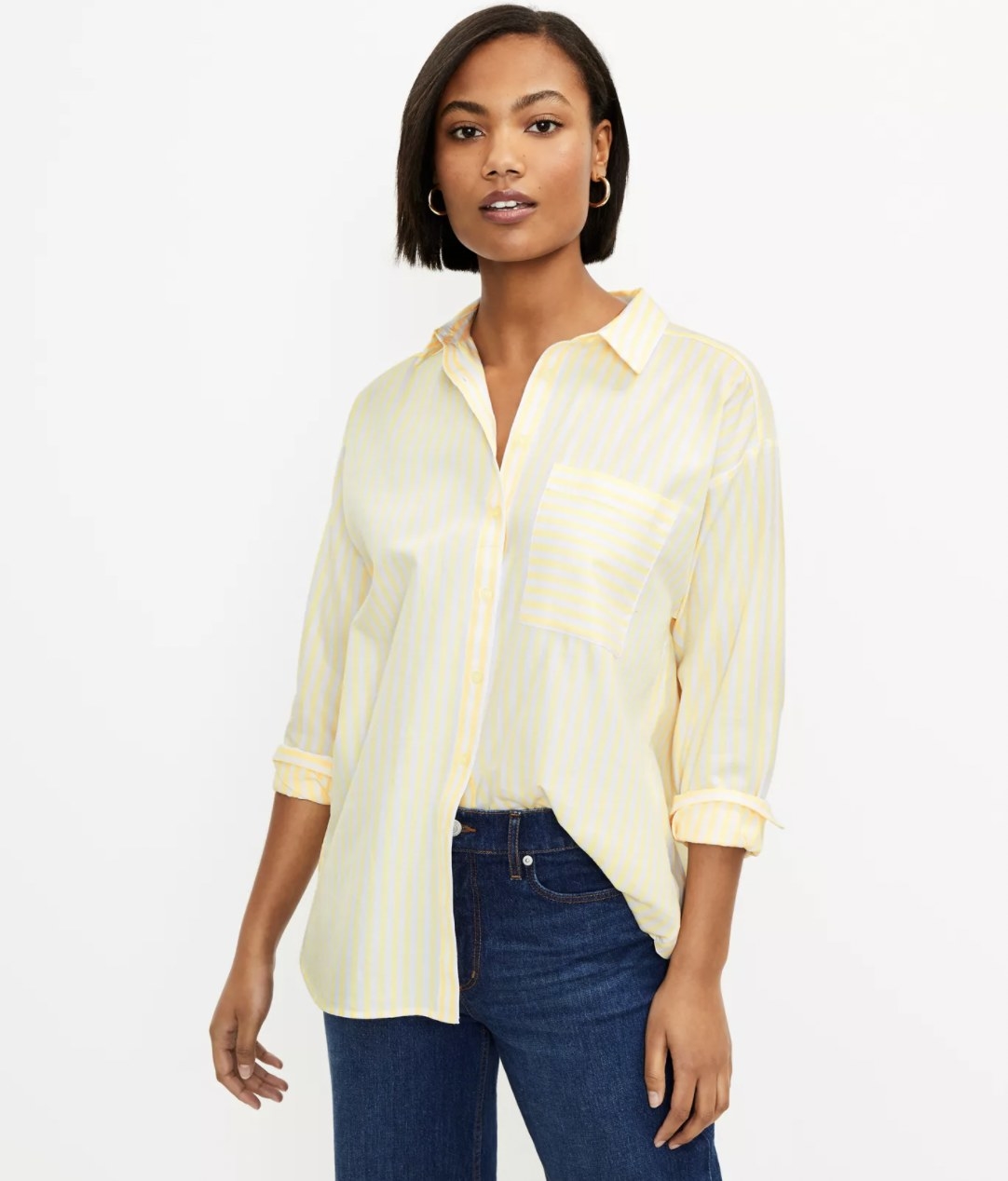 Model wearing the yellow striped shirt with sleeves rolled up and half of shirt tucked into jeans